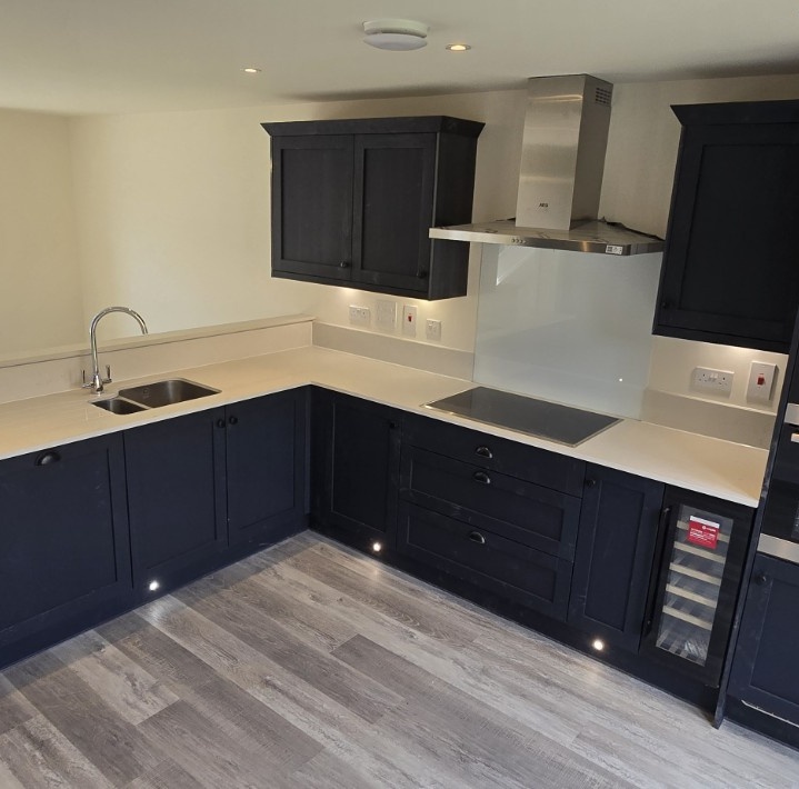 Detailed view of dark Shaker cabinetry, worktops and integrated hob