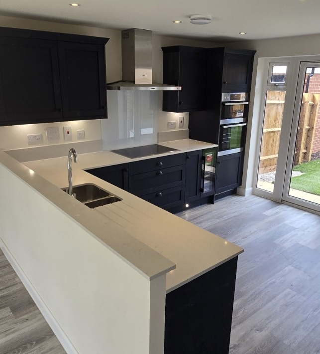 Completed dark Shaker kitchen with pale worktops and integrated appliances