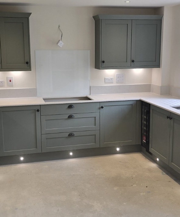 Fitted grey kitchen cabinetry with integrated lighting